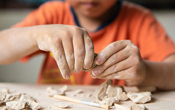 Kid playing with educational archaeology toy