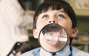 Boy sticking out his tongue onto a magnifying glass